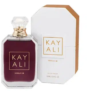 Flacon Kayali Vanilla 28 au jus ambré sombre posé devant son coffret blanc et doré épuré.