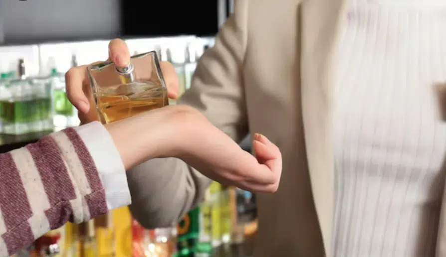 Personne testant un parfum sur le poignet dans une parfumerie spécialisée