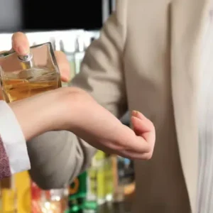 Personne testant un parfum sur le poignet dans une parfumerie spécialisée