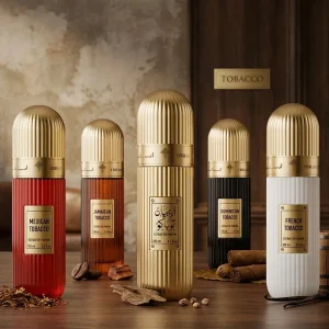 Cinq flacons de parfum dorés et colorés posés sur une table en bois sombre.